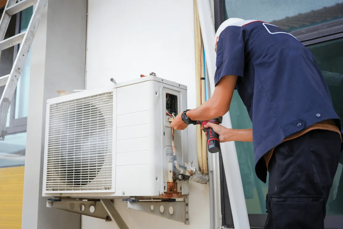 Technician servicing an outdoor air conditioning unit